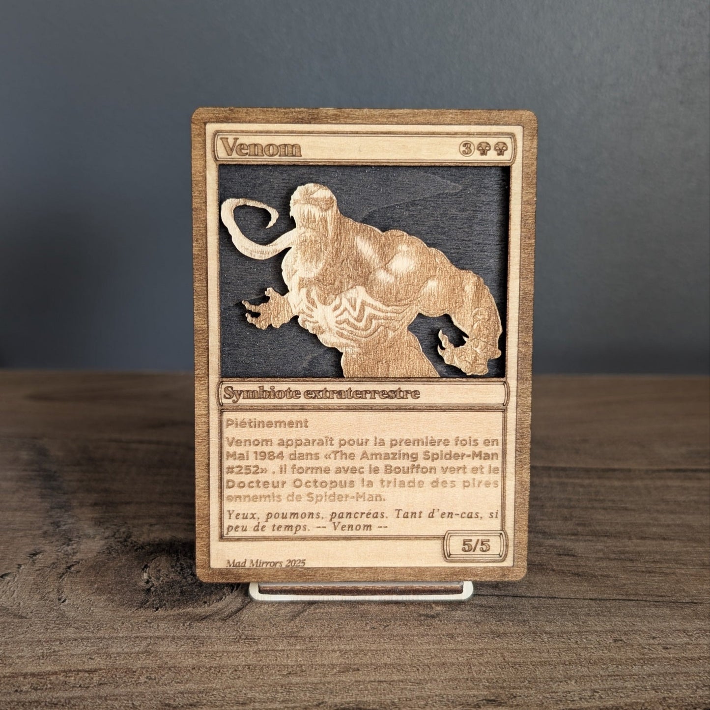 Carte Venom présentée sur support en bois