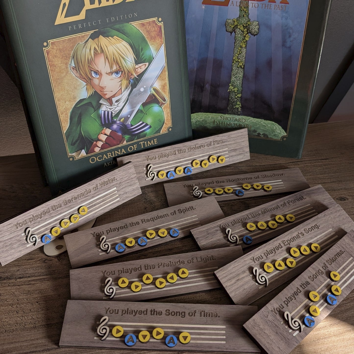 Toutes les mélodies actuellement disponibles sur ma boutique, présentées sur étagère avec des livres issus de l'univers Zelda