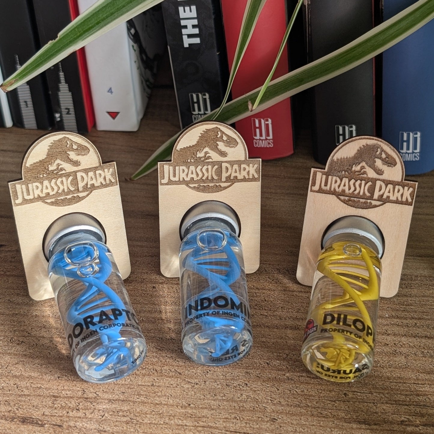 Vue de présentation des fioles 20mL avec leurs supports en bois gravés avec le logo Jurassic Park