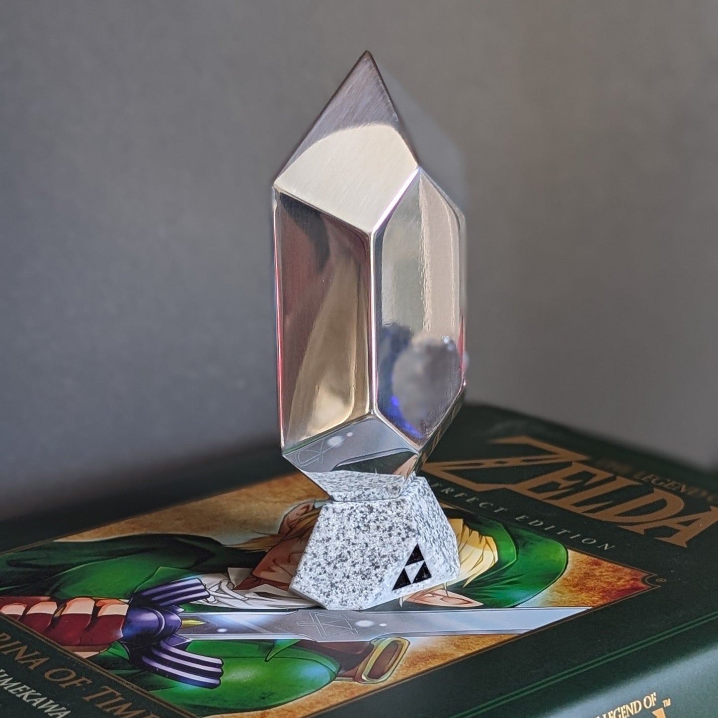Rubis Zelda en Aluminium posé sur un livre